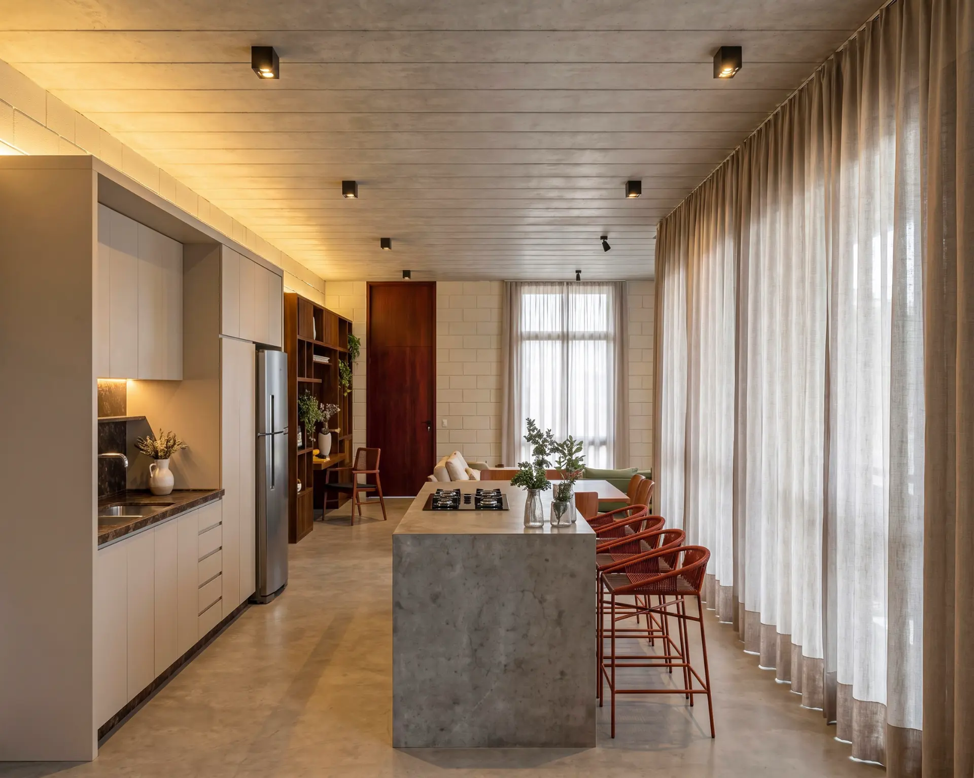 Linear kitchen with concrete island and terracotta stools